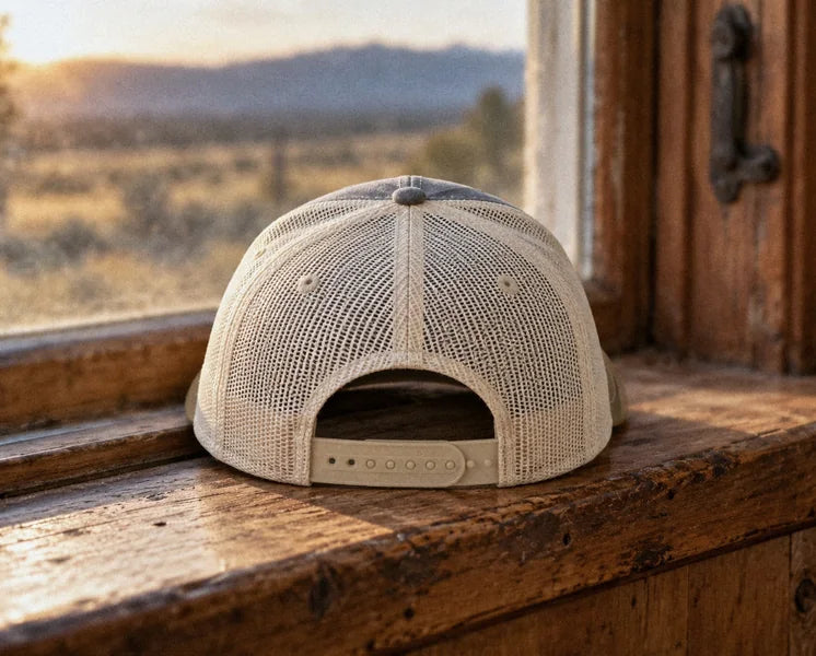 The cream mesh back and snapback strap, on a windowsill