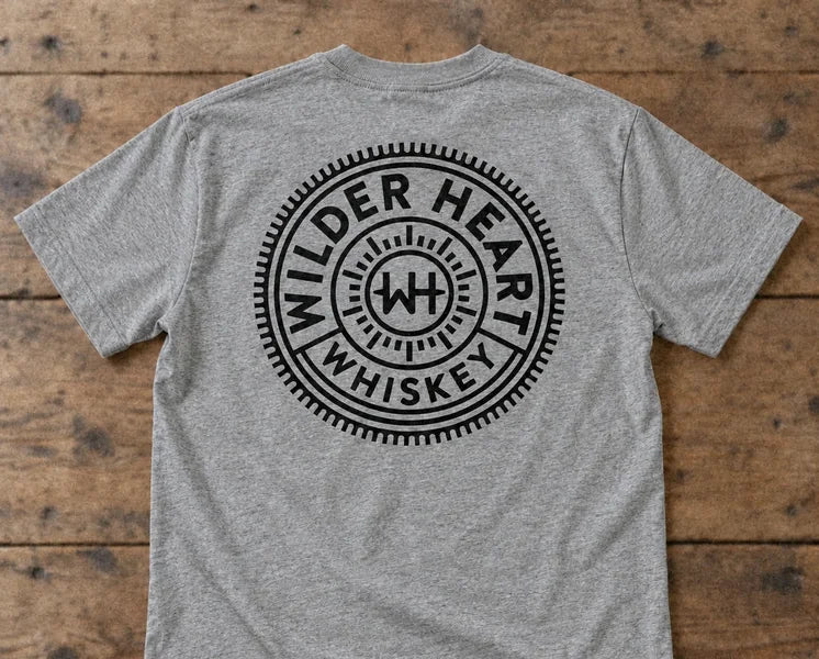 The back of the Gray tee with the black Wilder Heart Whiskey medallion