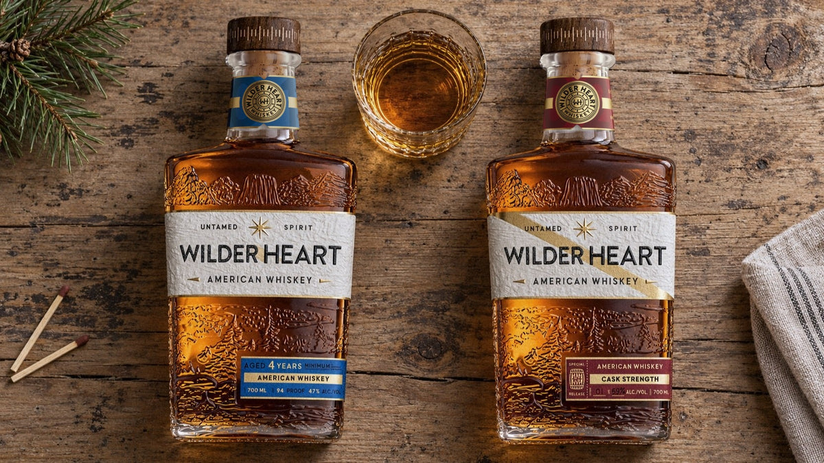 The Pair laid out on a pine table: Wilder Heart Whiskey and Cask Strength with a pour