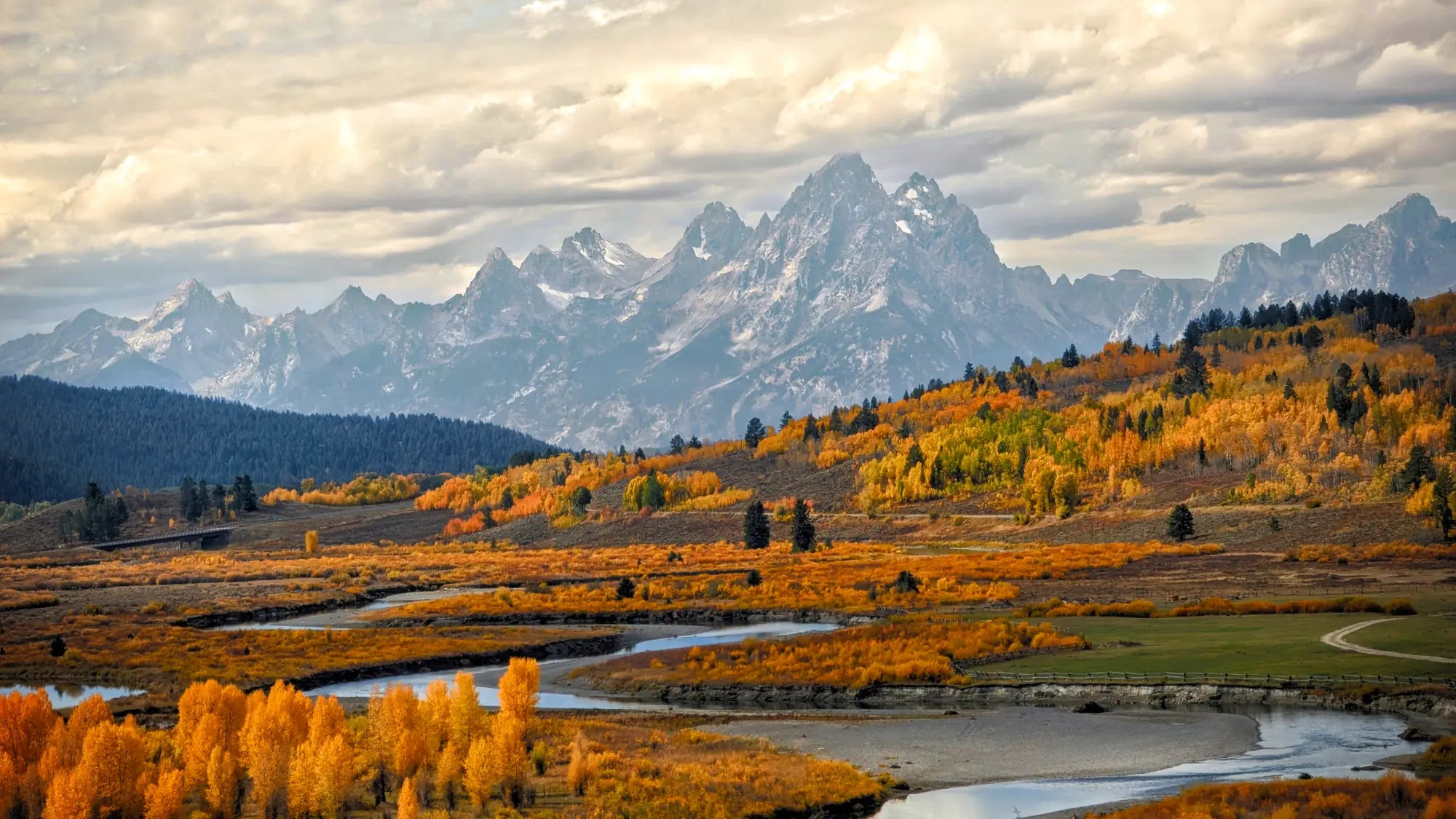 The Teton Range above a river valley in autumn