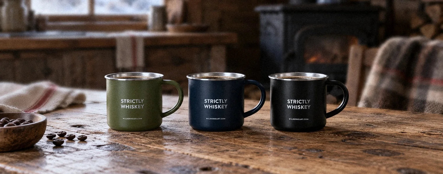 The camp mug in Green, Navy and Black on a cabin kitchen table at dawn